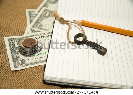 Opened notebook with a blank sheet, pencil, key and money on the old tissue