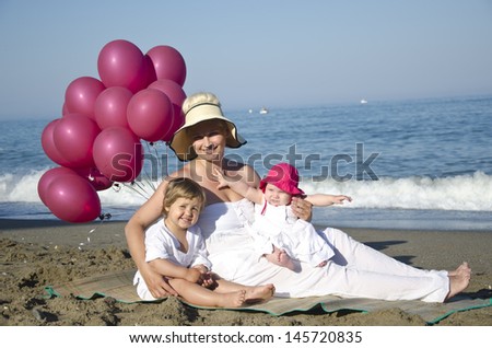 Family playing with balloons on the beach