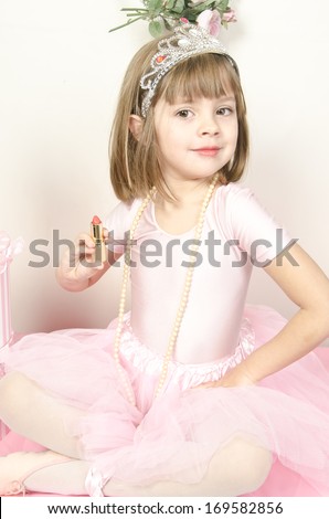 Funny little princess girl in silver crown and pink dress over white