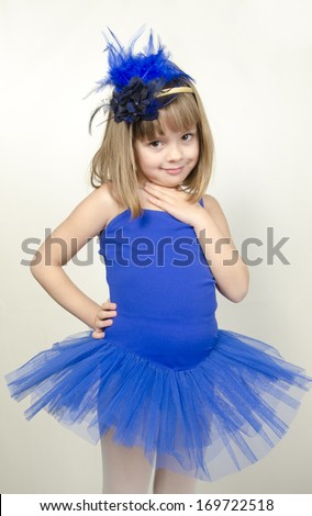 Portrait of an adorable preschool age girl playing dress up wearing a ballet tutu, isolated on white