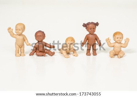Row of multiethnic babies sitting side by side looking away isolated on gray background