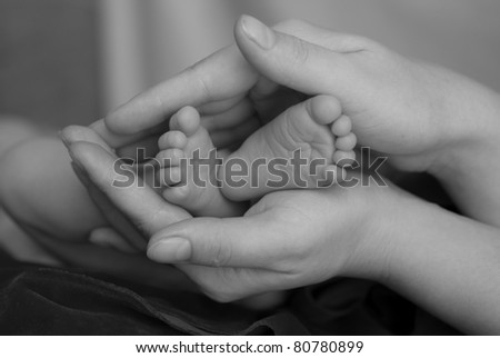 Baby\'s foot in mother hands.