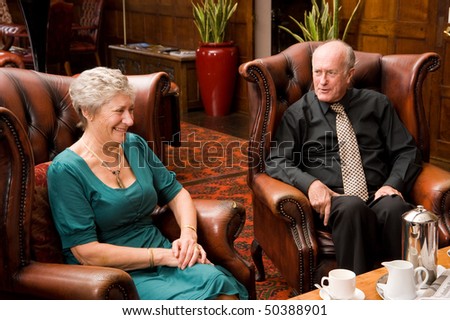 Group of happy older senior friends enjoying each others company in an expensive hotel