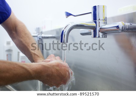 Surgeon washing hands prior to operation using correct technique for cleanliness