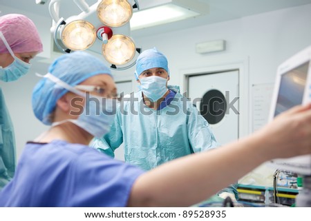 Surgical team performing operation on patient in modern theater