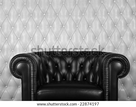 Black leather armchair near white wall