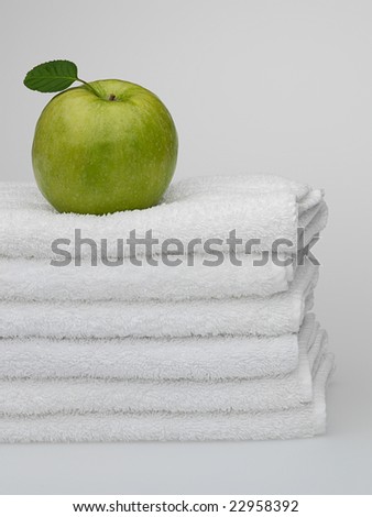 White towels with a green apple on a white background