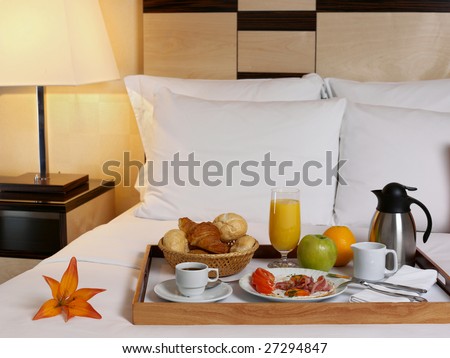 Tray with breakfast on a bed in a hotel room