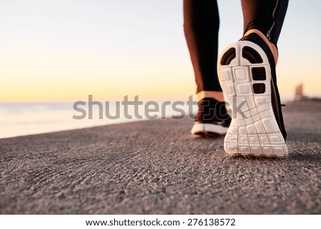 Runner man feet running on road closeup on shoe. Male fitness athlete jogger workout in wellness concept at sunrise. Sports healthy lifestyle concept.