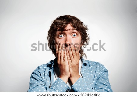 Closeup portrait of happy young handsome man looking shocked surprised in full disbelief hands on mouth open eyes, isolated on grey background. Positive human emotion facial expression feeling