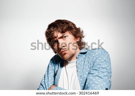 Closeup portrait distrust young man, guy, mad worker at isolated grey background. Negative emotions, facial expression