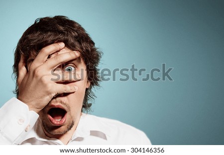 Closeup portrait of handsome young man looking shocked, surprised in disbelief, with hands on face looking at you camera, isolated on background. Positive human emotions, facial expressions