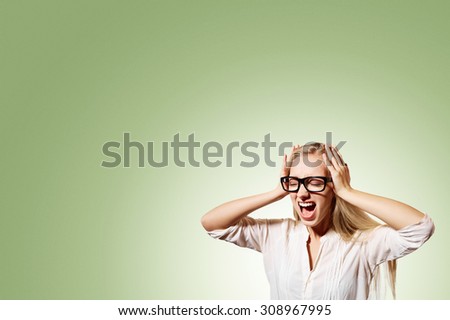 Portrait upset stressed young blonde business woman squeezing her head, going nuts, screaming, losing her mind, looking up isolated pistachio wall background. Negative emotion feeling reaction
