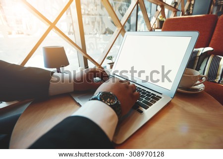 Bottom view portrait of successful business man using touch pad while standing in city financial street background, bearded man with sunglasses using internet at sunny day outdoors, flare light
