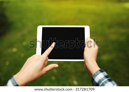 Tablet computer. Hipster woman using digital tablet computer PC. Girl touching tablet screen which is editable isolated on green background.
