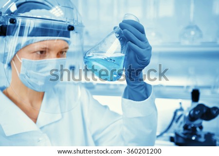 Closeup portrait female scientist holding conical tube with liquid solution, laboratory experiments, isolated lab background. Forensics, genetics, microbiology, biochemistry