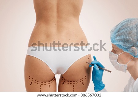 Cellulite cut out. Conceptual image, plastic surgery concept. Beautician touch and draw correction lines on woman. Before plastic surgery operetion. Isolated