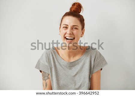 Funny woman on grey background. Cheerful female model joyful. Positive human emotion facial expression body language.