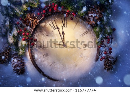 Christmas clock and fir branches covered with snow