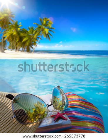 Straw hat, bag and sun glasses  on a tropical beach