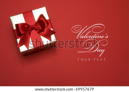 golden gift box with a red bow on red background