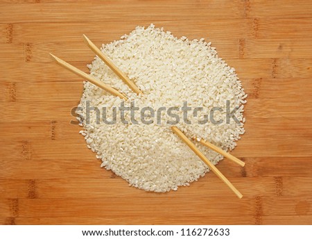raw rice and chopsticks on bamboo board
