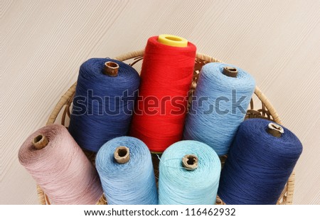 bobbin with thread in a basket on the table