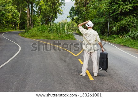 a man with a suitcase is on a fork in the road