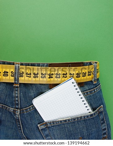 jeans with meter belt slimming and notebook in pocket on the green background