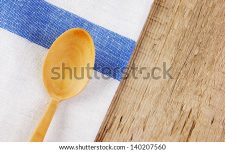 wooden spoon and dishcloth on old wooden table