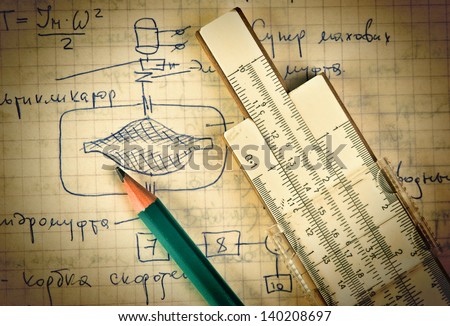 pencil and a slide rule on the old page with the calculations in mechanics