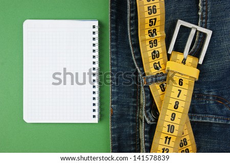 jeans with meter belt slimming and notebook on the green background