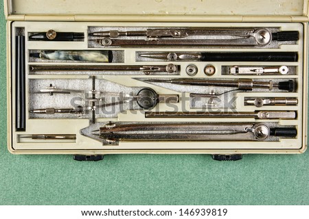 Old drawing tools in a box on a green background