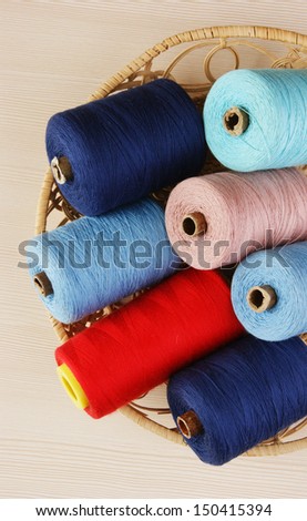 bobbin with thread in a basket on the table
