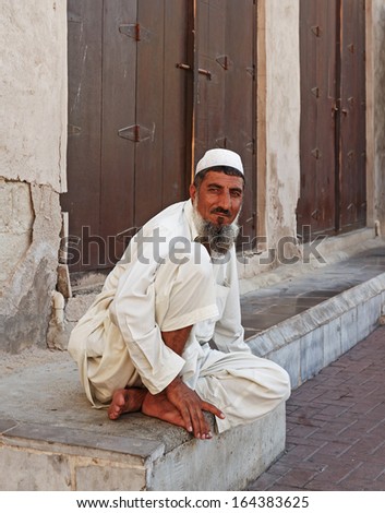 DUBAI, UAE-OCTOBER 30: Old man sitting on the stone steps of the old city of Bar Dubai on October 30, 2013. It is the oldest part of the city in Dubai, UAE