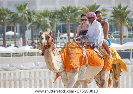 Dubai, Uae - November 16, 2012: Arab Man And Camel On Jumeirah Beach In Dubai At The Burj Al Arab Background. Dubai Was The Fastest Developing City In The World Between 2002 And 2008.