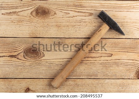 Old hammer on a wooden background