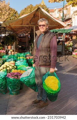 NICE, FRANCE - OCTOBER 30, 2014: Smiling seller florist in flower shop