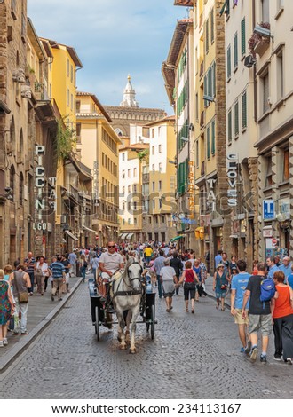 FLORENCE, ITALY - 23 JUNE, 2014: Tourists ride on a horse carriage on the street in Florence