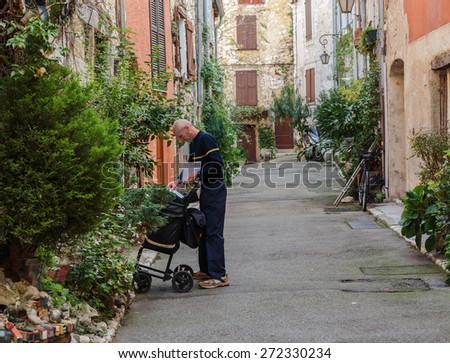 NICE, FRANCE - OCTOBER 30, 2014: The postman delivers mail on the street