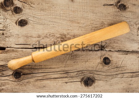 Old rolling pin on a wooden vintage board