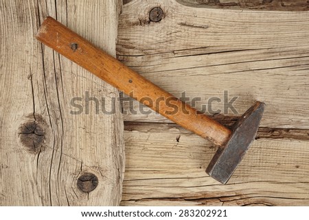 Old hammer on the dilapidated wooden planks