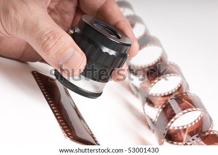 hand holding a magnifying glass and twisted film