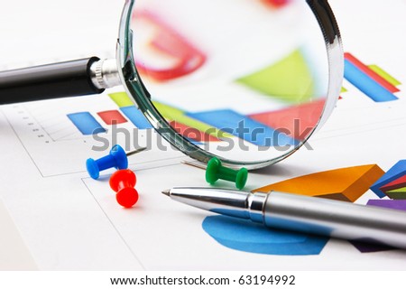 pen, magnifying glass and the working paper with a diagram