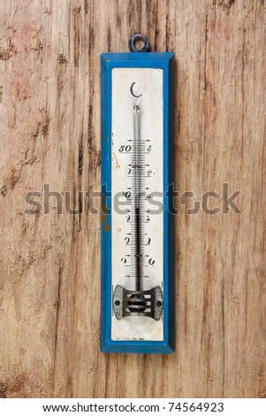 old thermometer on a wooden background