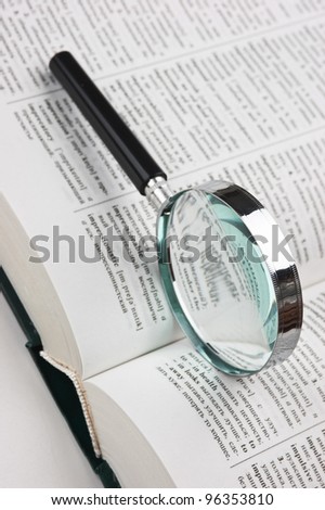 books and magnifying glass on white background