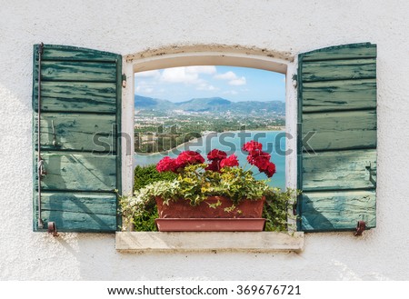 Sea view through the open window with flowers in Italy