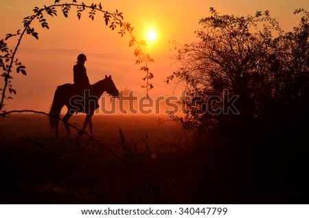 Young girl riding on horse during wonderful calm and peaceful autumn morning full of mist and gold light on the meadow in slovakia