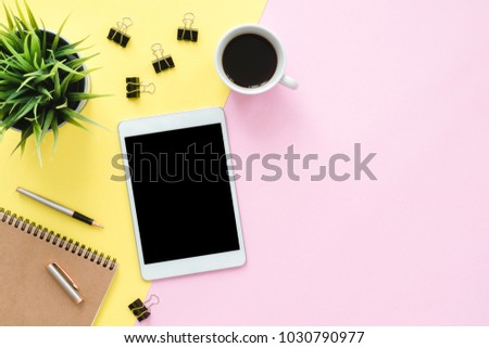 Office desk working space - Flat lay top view photo of working space with blank mock up tablet, coffee cup and notebook on pastel background. Pastel pink yellow color copy space working desk concept.