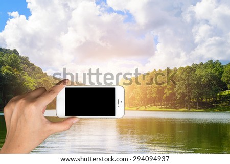Smart phone camera taking photo picture of Pang-Ung lake. Closeup of mobile phone camera screen photographing beautiful thailand landscape Pang-Ung lake, Mae Hong Son, Thailand.